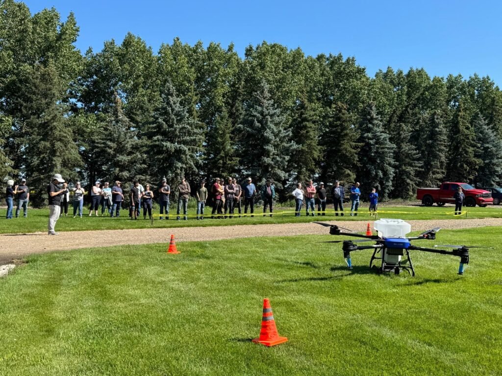 field of people watching a agriculture drone demo